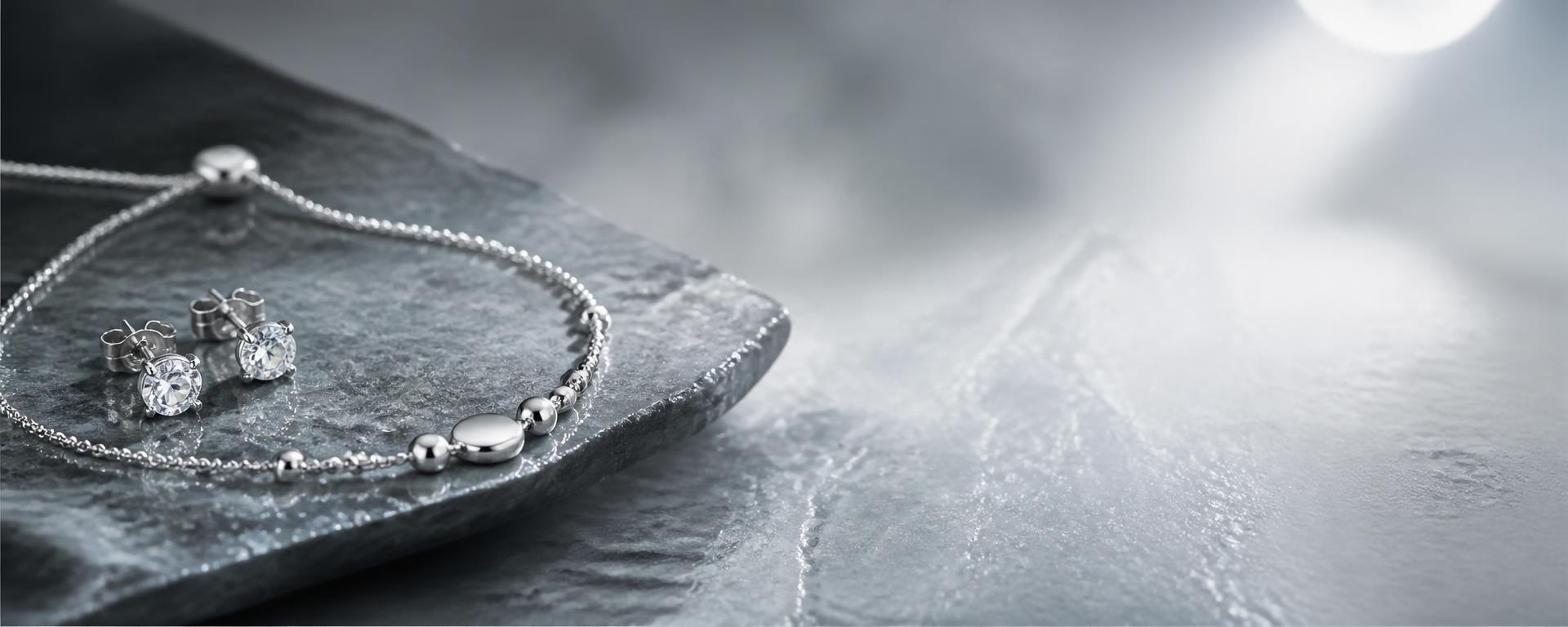 Lunaire 925 silver studs and bracelet on cool grey stone